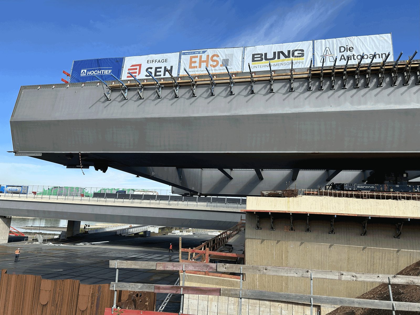 Auskragender Stahlüberbau der Rheinbrücke Leverkusen mit Bautafeln der Beteiligten