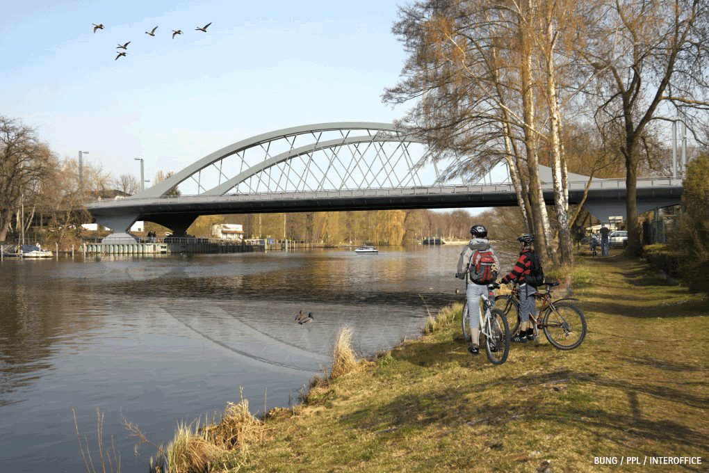 Die Freybrücke in Berlin über die Havel, im Vordergrund zwei Radfahrende am Ufer