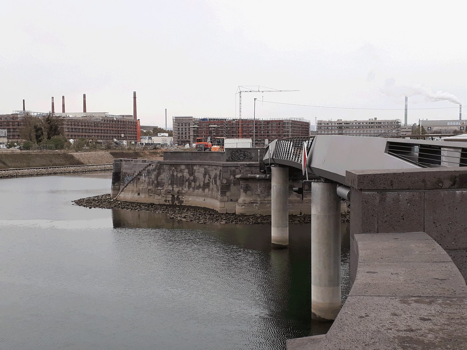 Sanierte Kaimauer im Zollhafen Mainz, im Hintergrund die Stadtsilhouette
