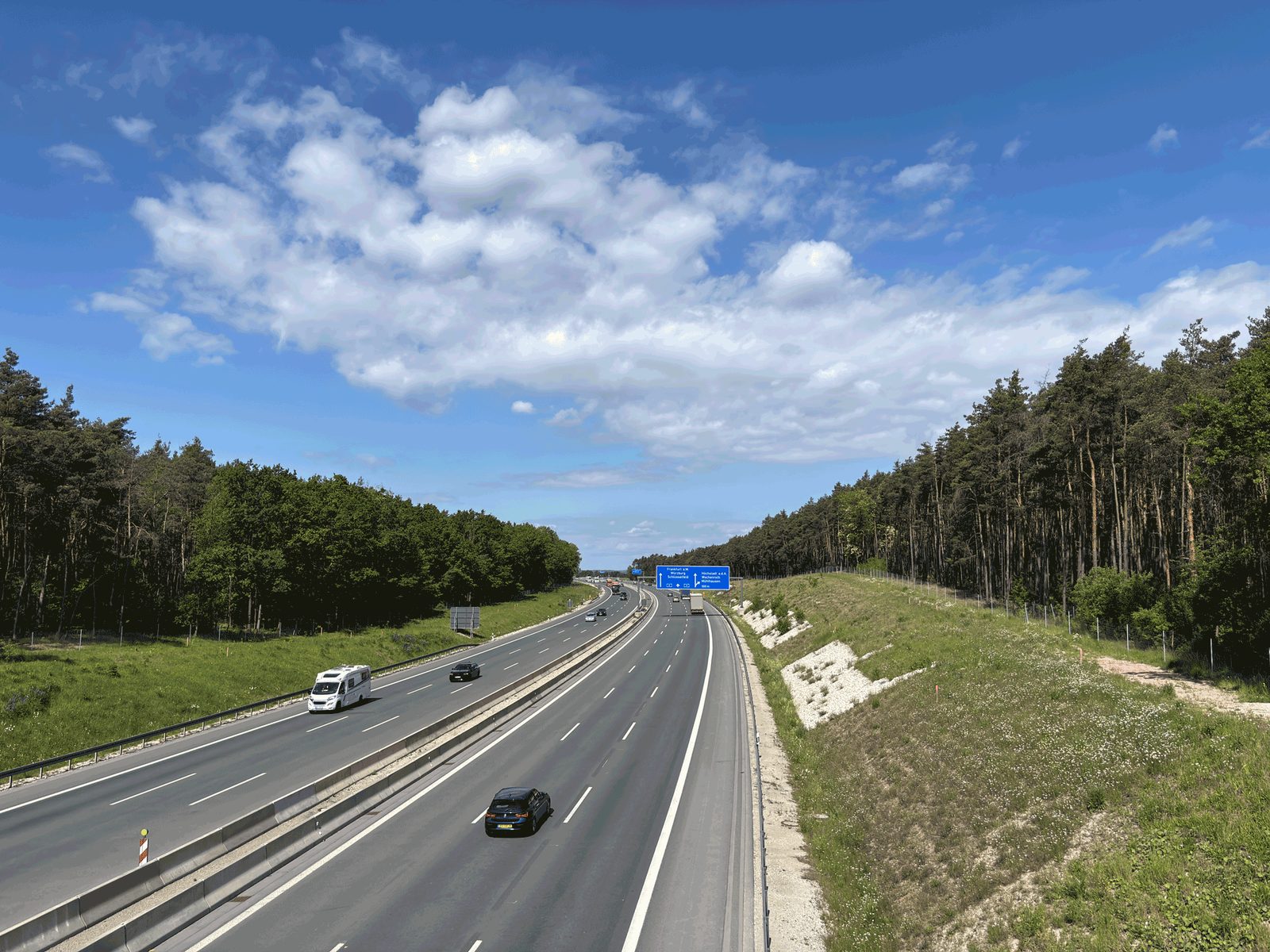 Die A 3 zwischen Wald unter blauem Himmel mit wenigen Fahrzeugen