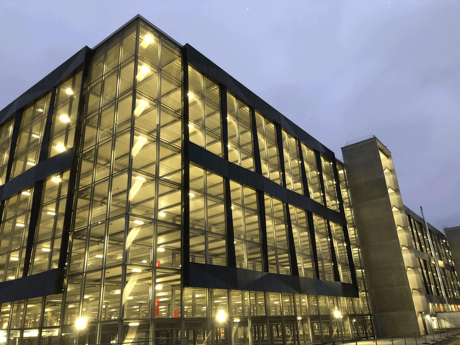 Das Parkhaus Terminal 3 bei Nacht mit durchleuchteten Parkebenen