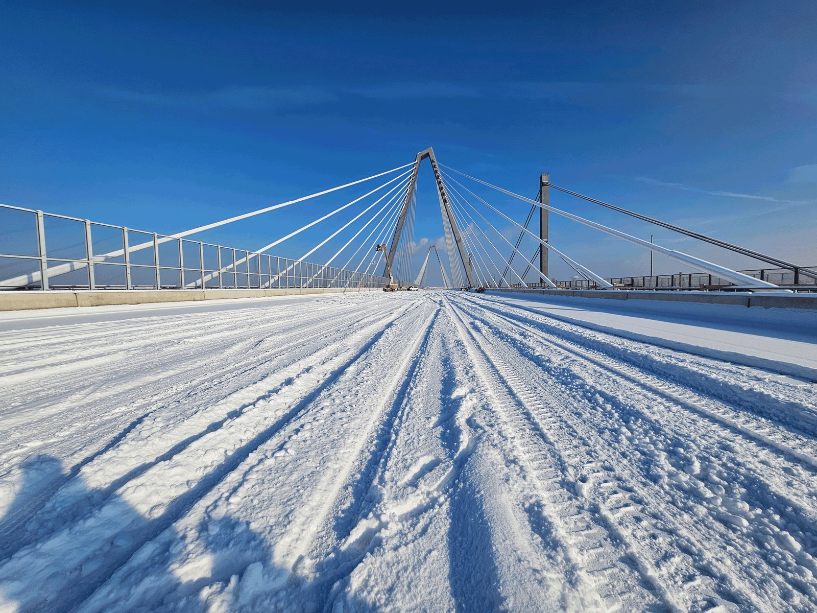Verschneite Fahrbahn der Rheinbrücke mit Pylon und Seilen