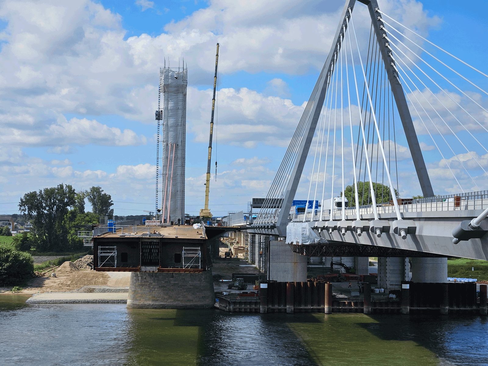 Pylon der Rheinbrücke im Bau, daneben ein Kran